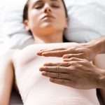 A person's hands on a woman's chest